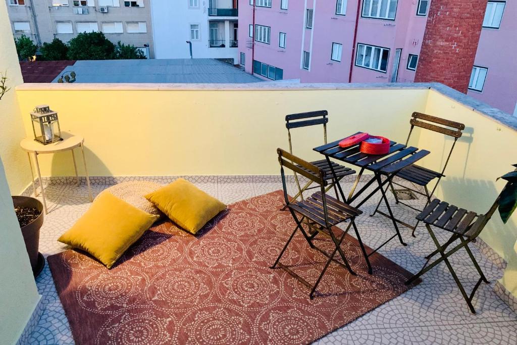 uma mesa e cadeiras sentadas numa varanda com uma mesa e uma mesa em Jolly Jolie w Terrace em Lisboa