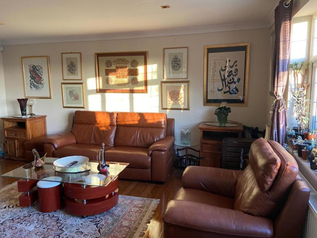 a living room with brown leather couches and a table at 2-Bed Apartment in High Wycombe Private Garden in High Wycombe