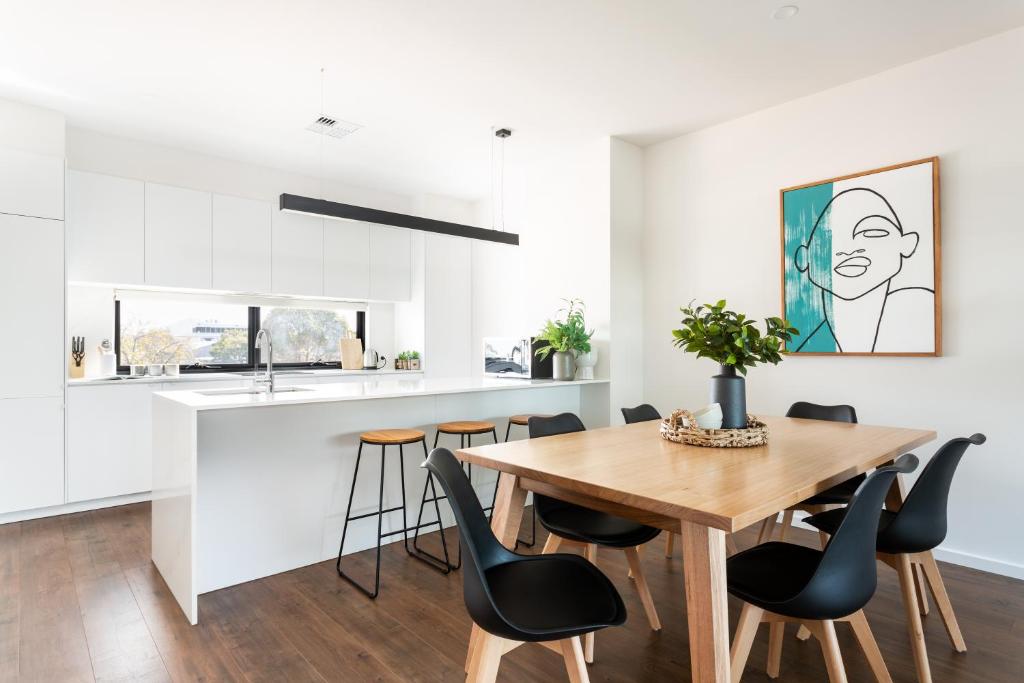 een keuken en eetkamer met een houten tafel en stoelen bij Little Grenfell Apartments by Urban Rest in Rose Park