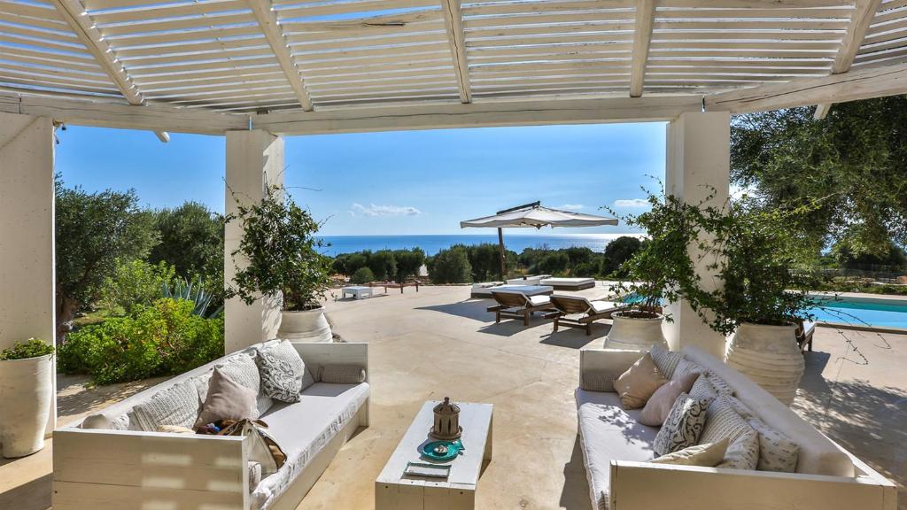 d'une terrasse avec canapés et vue sur l'océan. dans l'établissement VILLA PAJARE FRANCESI 8&2, Emma Villas, à Castrignano del Capo