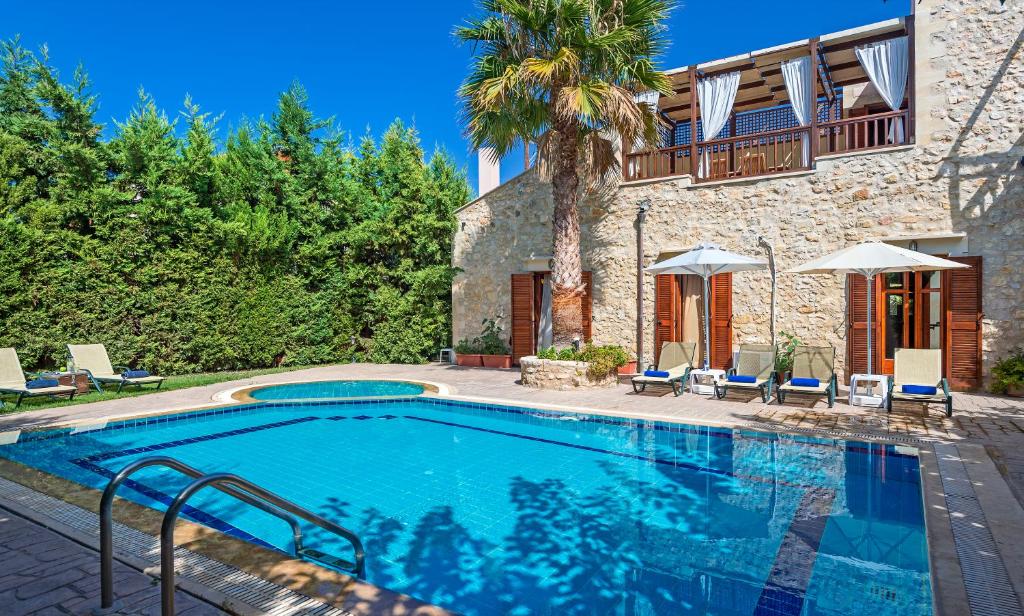 a swimming pool in front of a house at Amazing Villas in Crete in Astérion