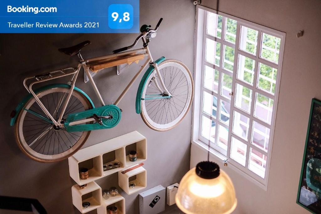 Una bicicleta colgada en una pared junto a una ventana en Leónidas Design Loft en Mendoza