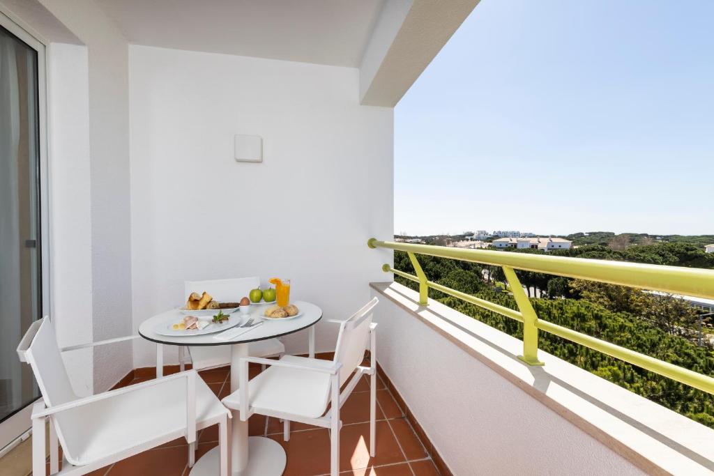 a balcony with a table and chairs and a view at The Patio Suite Hotel in Albufeira