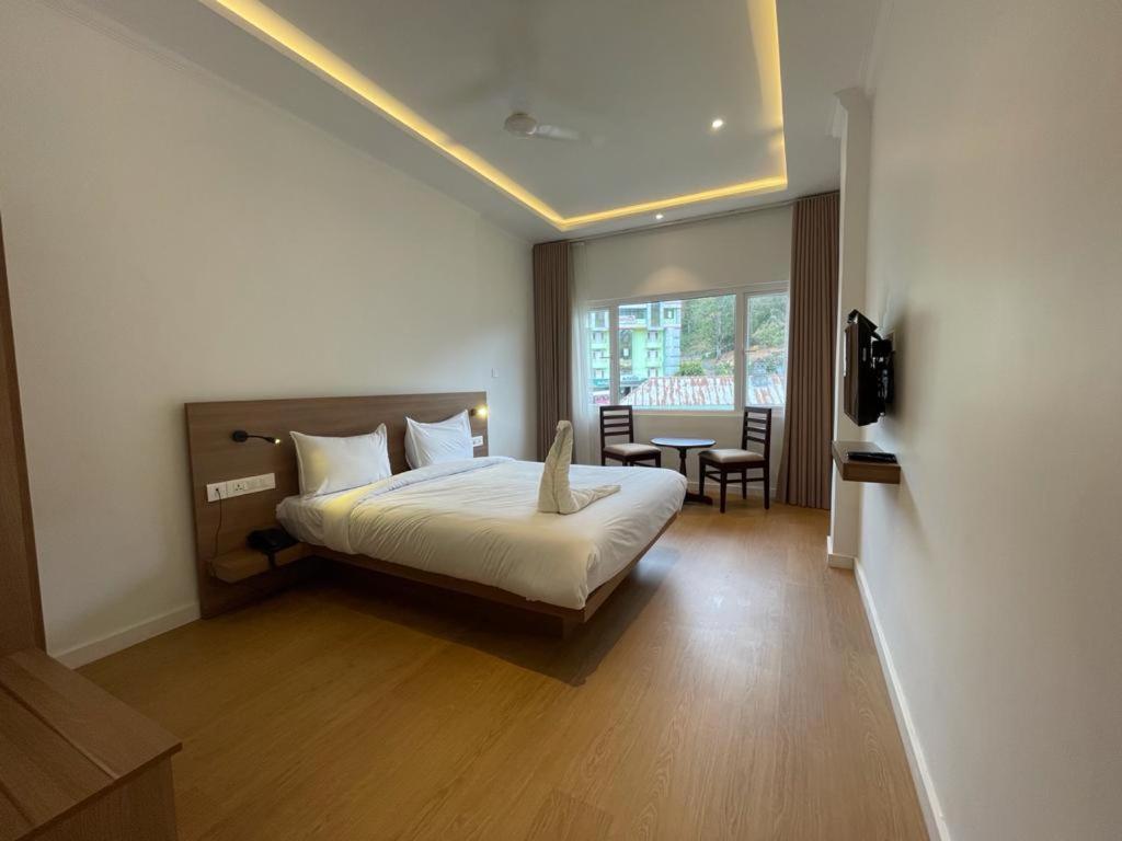 1 dormitorio con 1 cama, mesa y sillas en Tea Garden Riverside, en Munnar