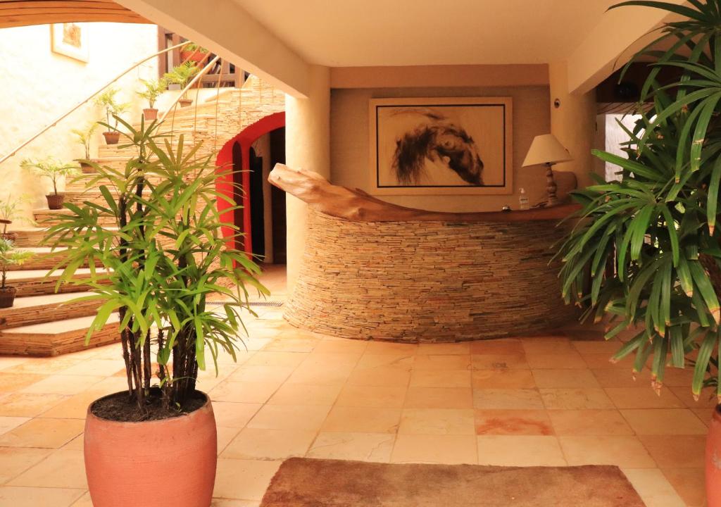 une chambre avec des plantes et une photo d'un cheval sur le mur dans l'établissement Pousada Dos Artistas, à Praia do Forte