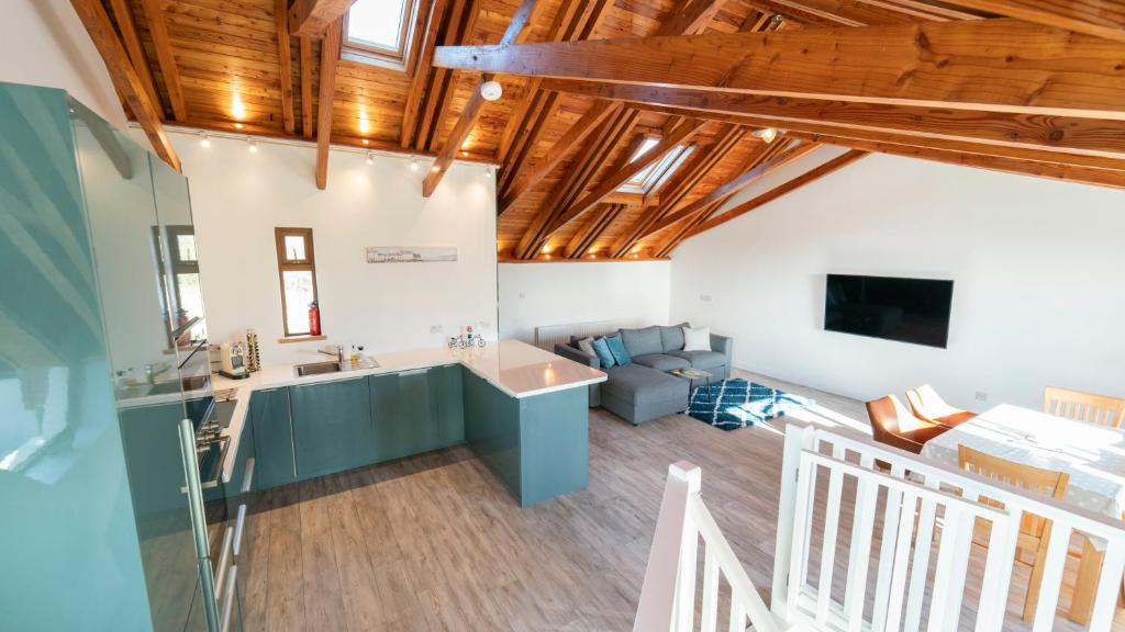 a kitchen and living room with wooden ceilings at Stylish, Spacious Sea View House in Galway