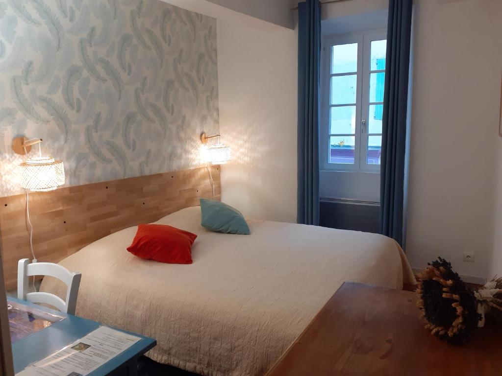 a bedroom with a bed with two pillows on it at La Maison Bleue in Sault-de-Vaucluse