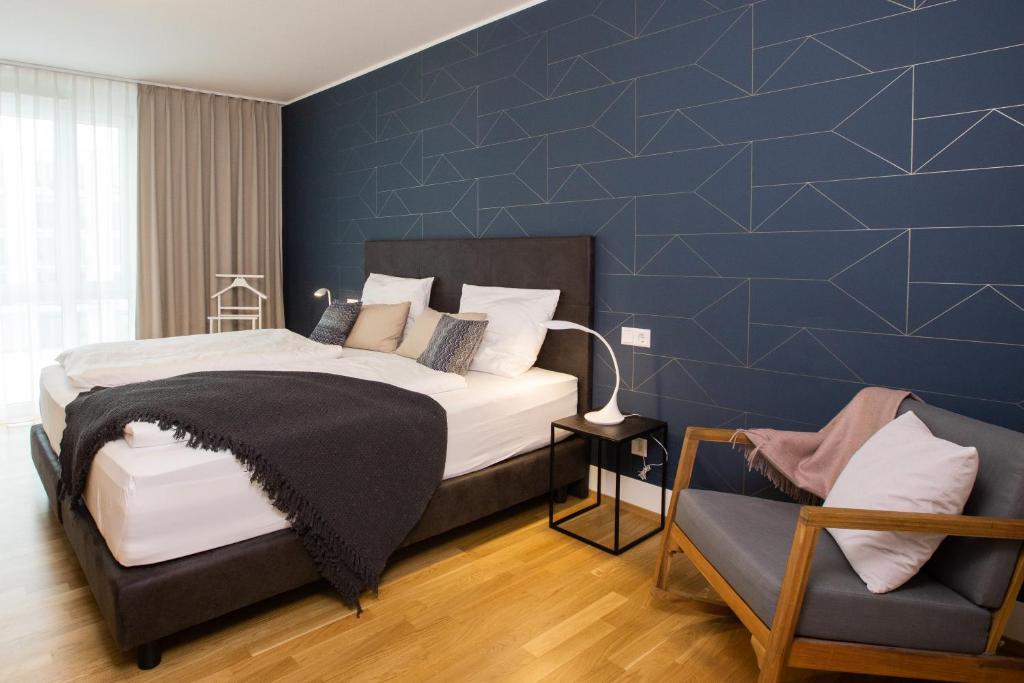 um quarto com uma cama e uma parede azul em Ferienwohnung Pfänder em Friedrichshafen