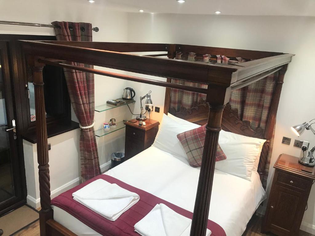 a bedroom with a canopy bed with white sheets at Hot Tub Hide Away near Alton Towers staffordshire in Cheddleton