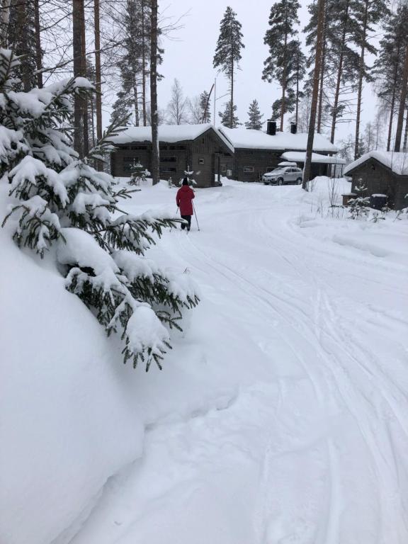 a person is skiing down a snow covered road at Beautiful lakeside Villa Vetojärvi in Pennala