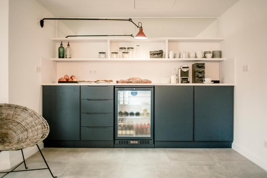 cocina con armarios verdes y nevera abierta en Tramuntana Hotel - Adults Only, en Cadaqués