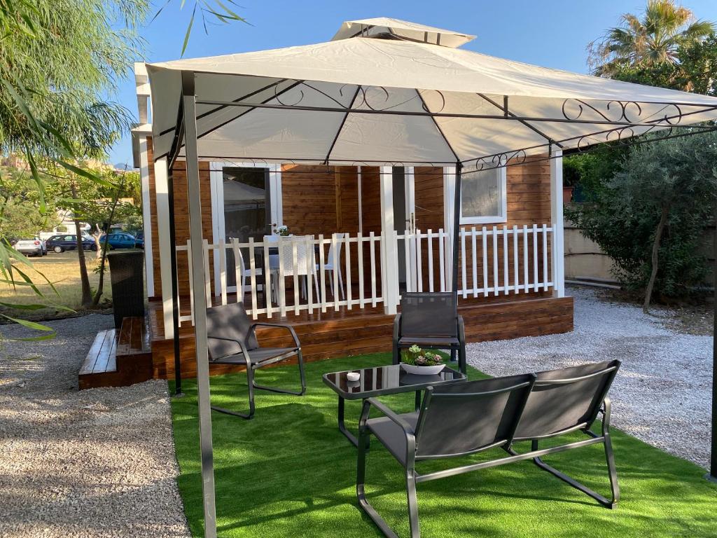 a gazebo with chairs and a table under it at Camping roccella mare in Campofelice di Roccella