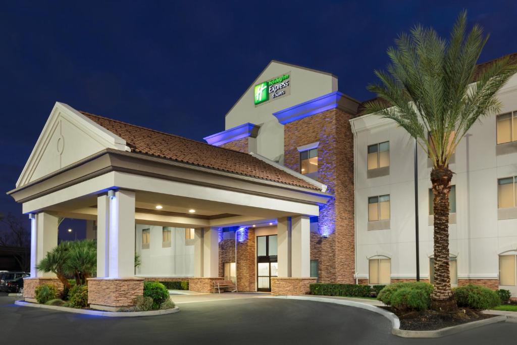 un hotel con una palma di fronte a un edificio di Holiday Inn Express Hotel & Suites Merced, an IHG Hotel a Merced