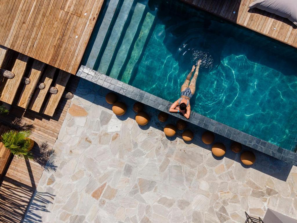 a man is swimming in a swimming pool at Makena Hotel in Icaraí