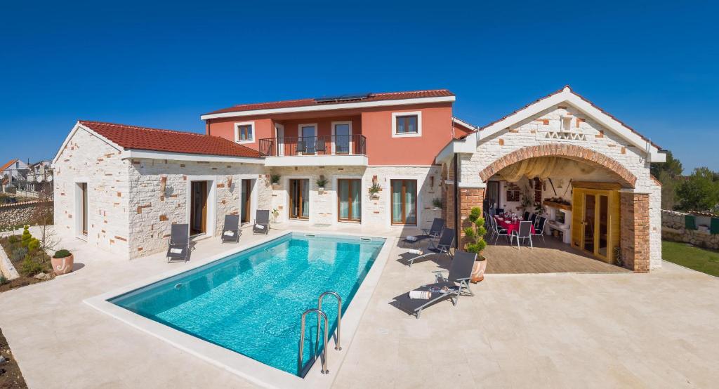 a villa with a swimming pool and a house at Villa Mediterranean Paradise in Šibenik