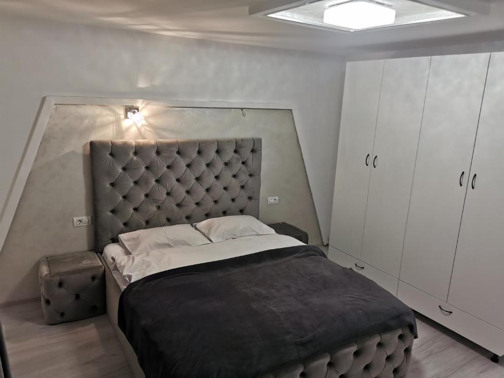 Schlafzimmer mit einem großen Bett mit einem gepolsterten Kopfteil in der Unterkunft Jolie Luxury Apartments II in Timişoara