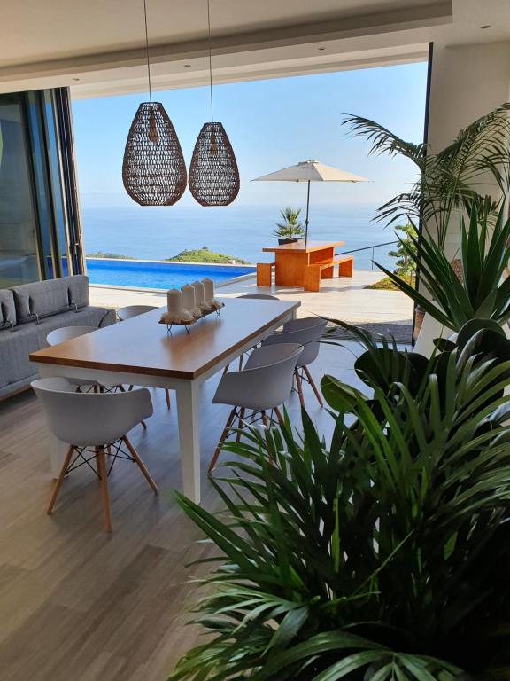 a dining room with a table and chairs and the ocean at Villa Brava Atlântico in Ribeira Brava