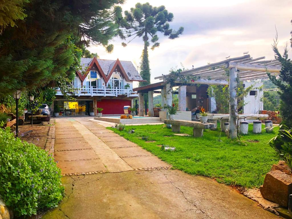 a house with a pathway in front of a yard at Campos House in Campos do Jordão