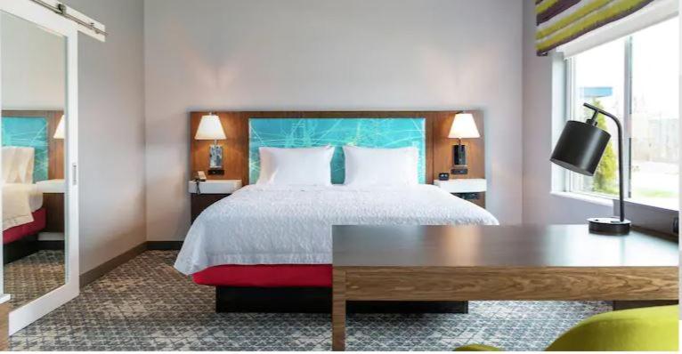 - une chambre avec un lit, une table et une fenêtre dans l'établissement Hampton Inn & Suites Marshfield, Wi, à Marshfield