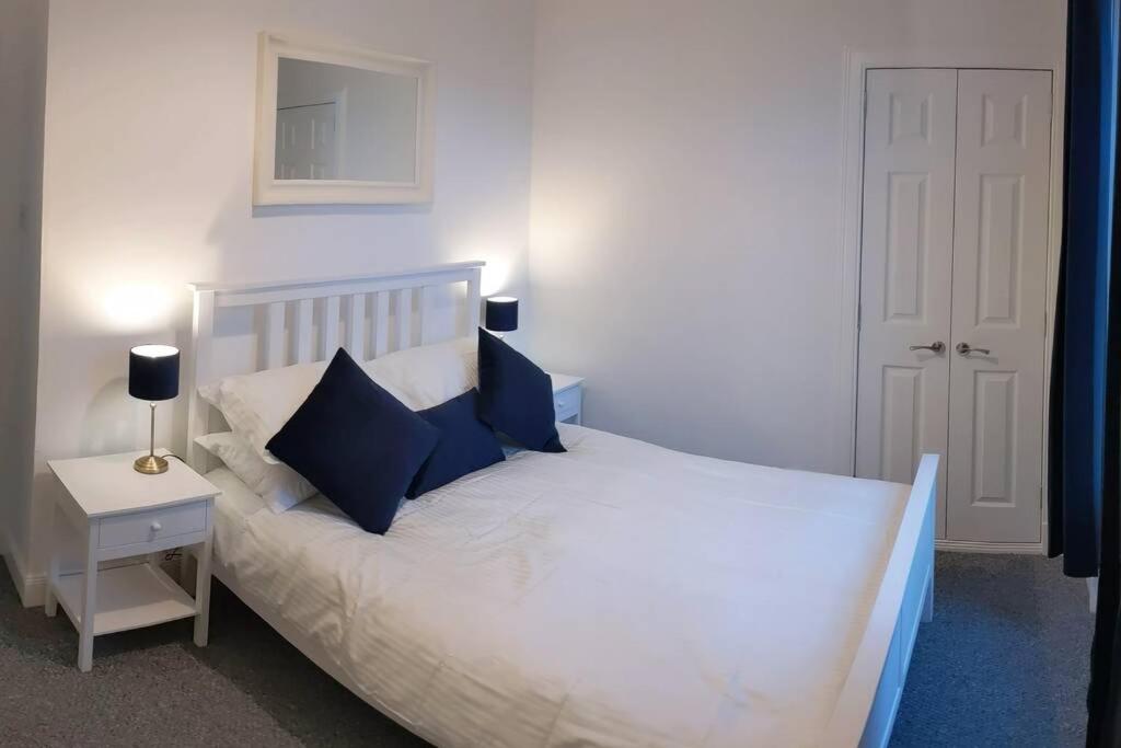 a bedroom with a white bed with blue pillows at Apartment 124 in Fife