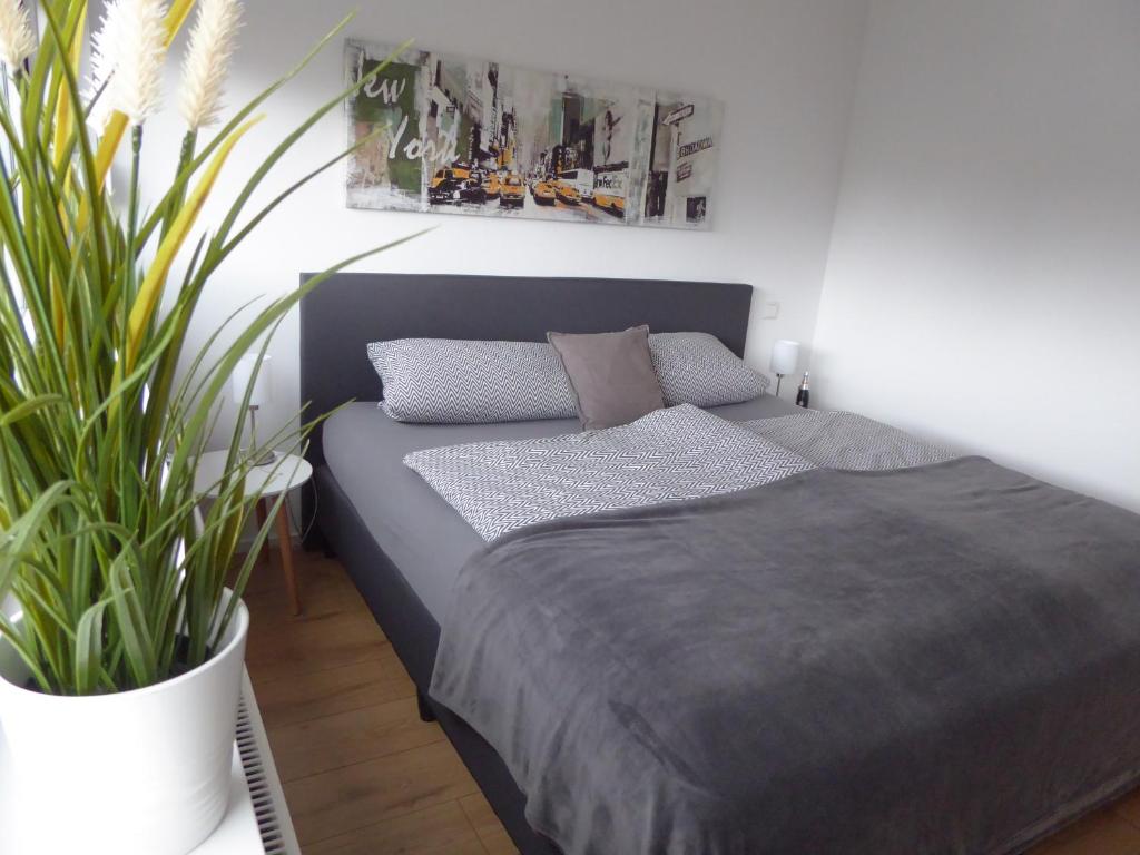 ein Schlafzimmer mit einem Bett und einer Topfpflanze in der Unterkunft Ferienwohnung Scharnhorst in Teningen