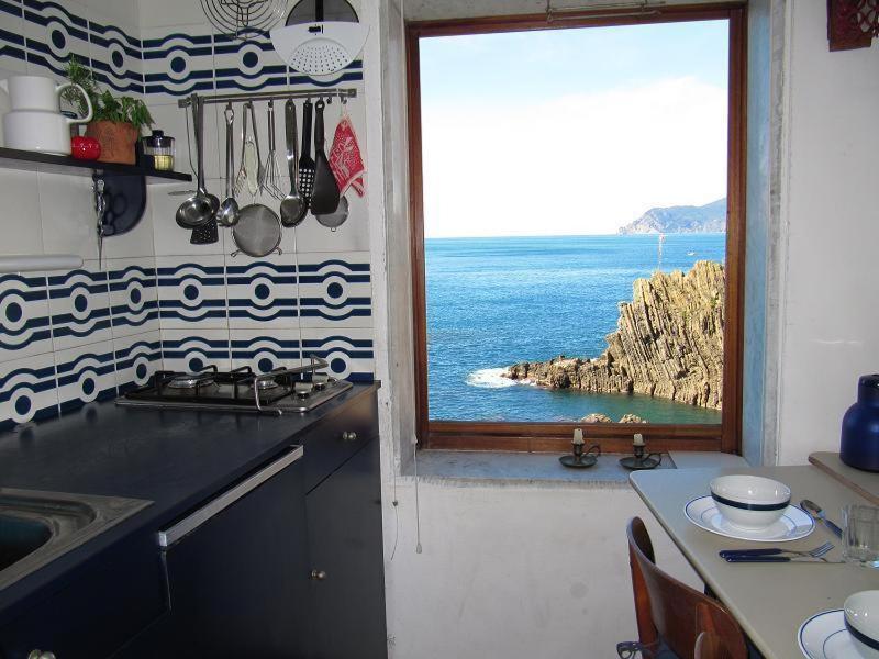 リオマッジョーレにあるヴォーチェ デル マーレの窓から海の景色を望むキッチン