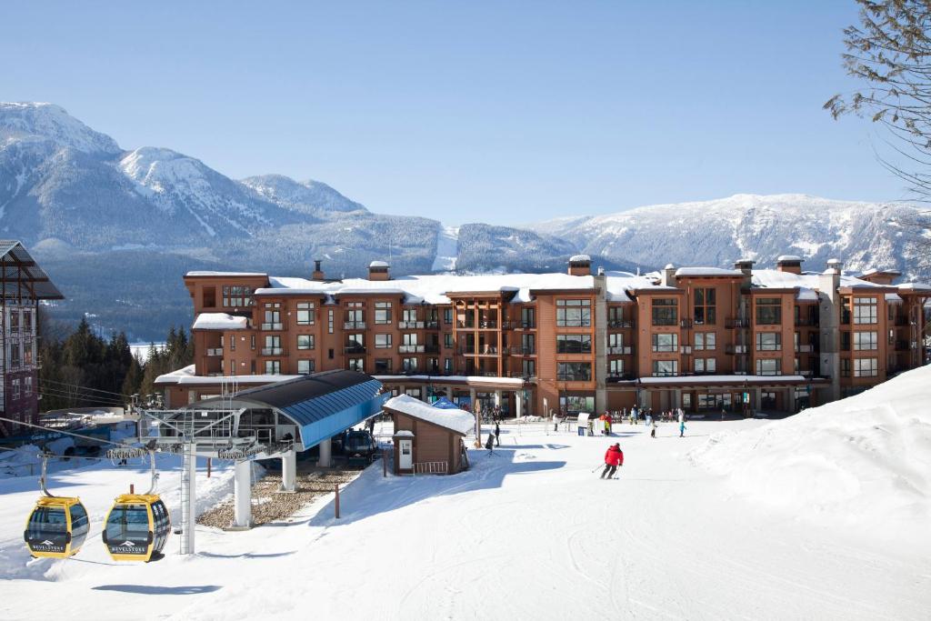 una estación de esquí en la nieve con un edificio en Sutton Place Hotel Revelstoke Mountain Resort, en Revelstoke