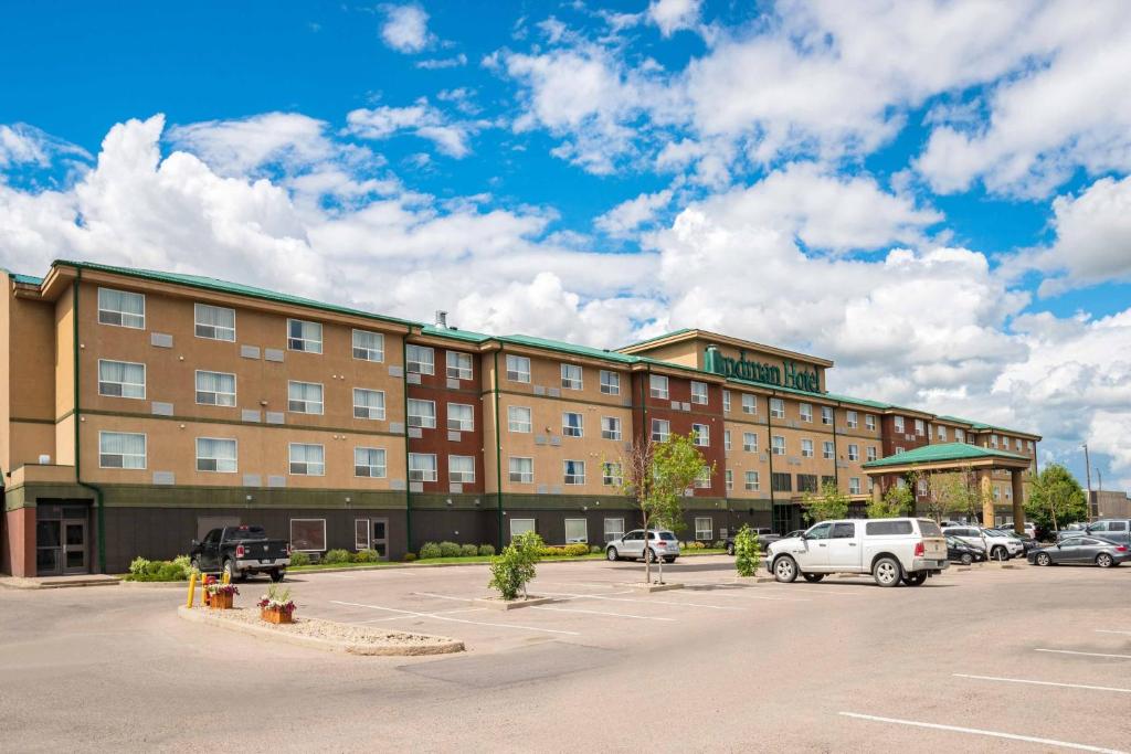 um grande edifício com carros estacionados num parque de estacionamento em Sandman Hotel Saskatoon em Saskatoon