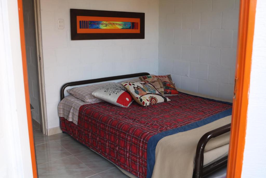 - une petite chambre avec un lit et des oreillers dans l'établissement Casita entera economica El Altillo, à Salento