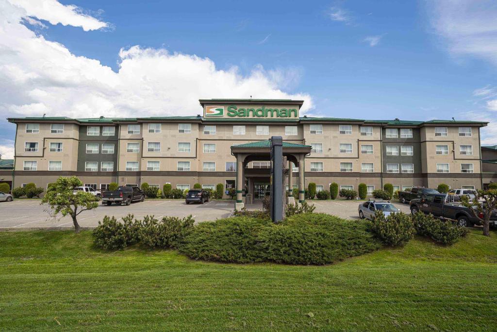 ein großes Gebäude mit einem Parkplatz davor in der Unterkunft Sandman Hotel Quesnel in Quesnel