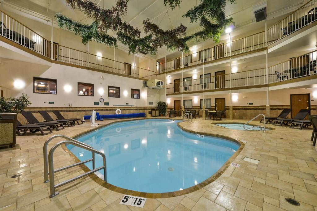 a large swimming pool in a large building with chairs at Motel 6 Minot, ND in Minot