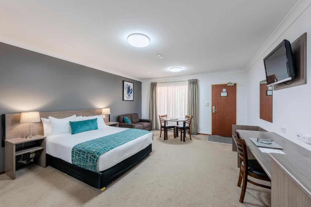 Best Western Plus Ambassador Orange في أورنج: غرفة في الفندق مع سرير ومكتب