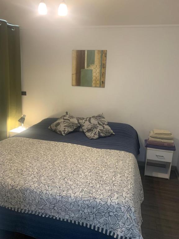 1 dormitorio con 1 cama con manta azul y blanca en Selma Apartment Ñuñoa Best Suite, en Santiago