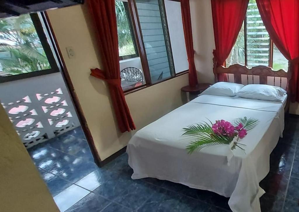 a bedroom with a white bed with flowers on it at Cupido - Playa Tambor in Tambor