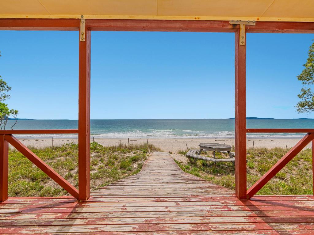 a wooden walkway to the beach with a view at Poppy's Beach House - Beachfront Whangapoua Home in Whangapoua