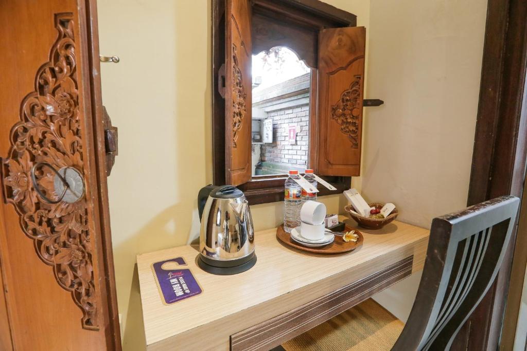 stół z czajnikiem na nim przed oknem w obiekcie Ubud Hotel & Cottages w mieście Malang