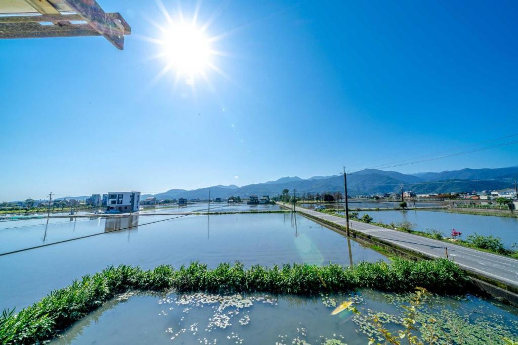 una piscina de agua con el sol en el cielo en Yilan Real Fun Homestay, en Dongshan