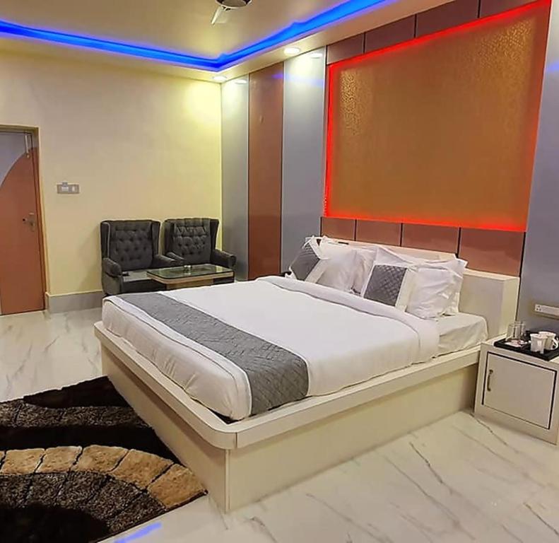 a bedroom with a large bed and a chair at Gokul Raj By WB Economy , Madhubani in Madhubani
