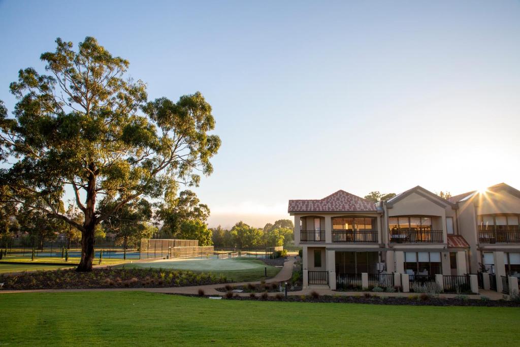 a house on the golf course with a tree at Hidden Valley Resort in Wallan