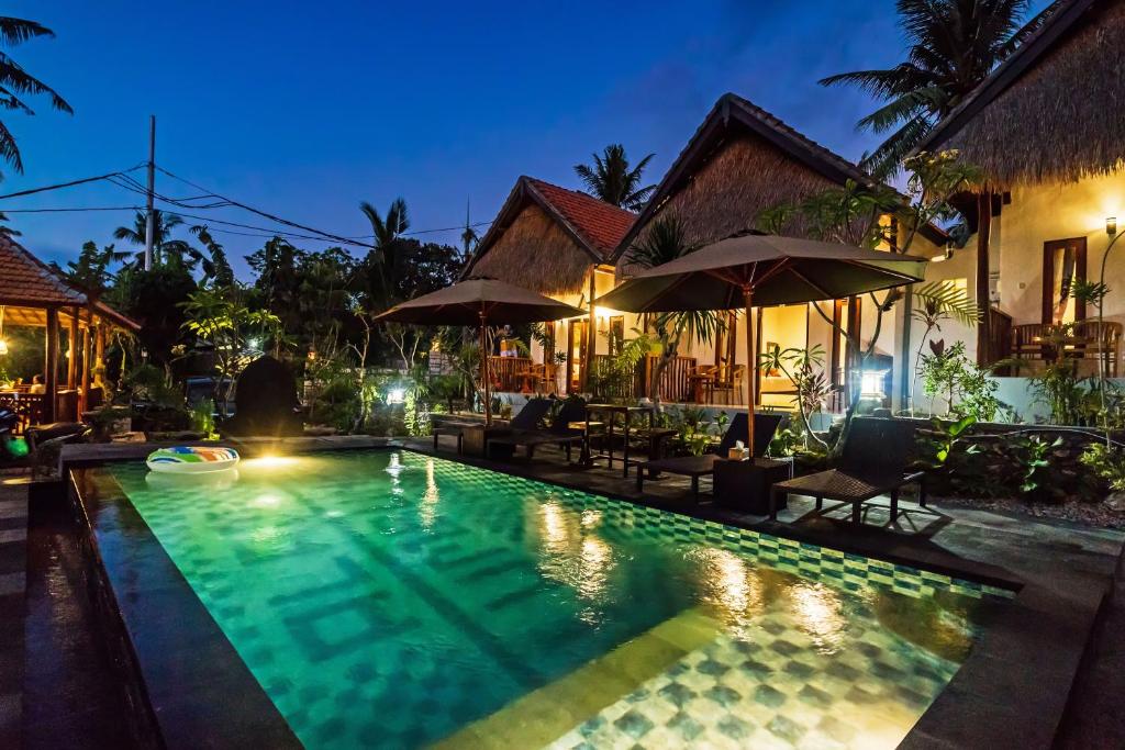 a swimming pool in front of a house at night at Alam Selumbung Garden in Nusa Penida