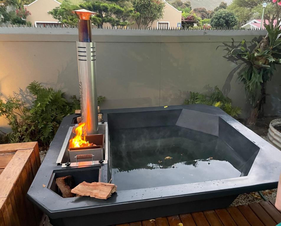 a fire pit on a patio with a fire at Seven on Flora- Hot Tub, Modern with amazing outside area in Hermanus