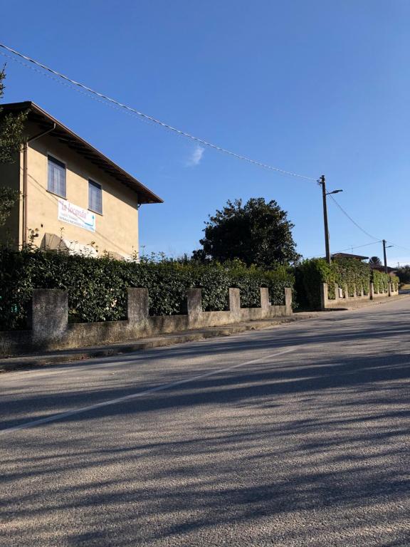 una calle con una valla al lado de un edificio en La Locanda Di Perico Paola, en Veruno