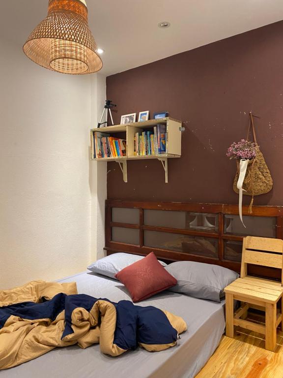 a bedroom with a bed and a book shelf at Hostel-John Cafe and Beer in Da Lat