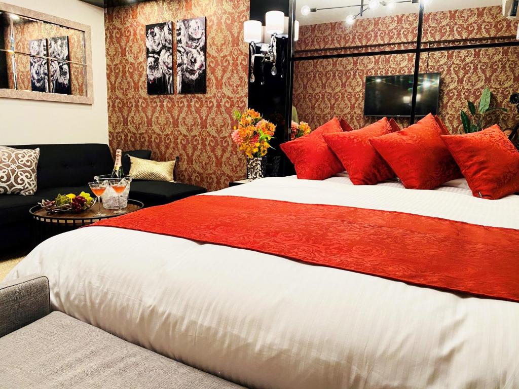 a bedroom with a large bed with red pillows at @RLiS_house大阪ドームシティ in Osaka