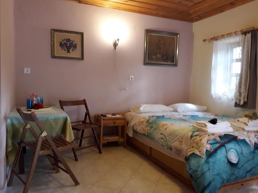 a bedroom with a bed and a table and chairs at Mystic Lake in Koukouli