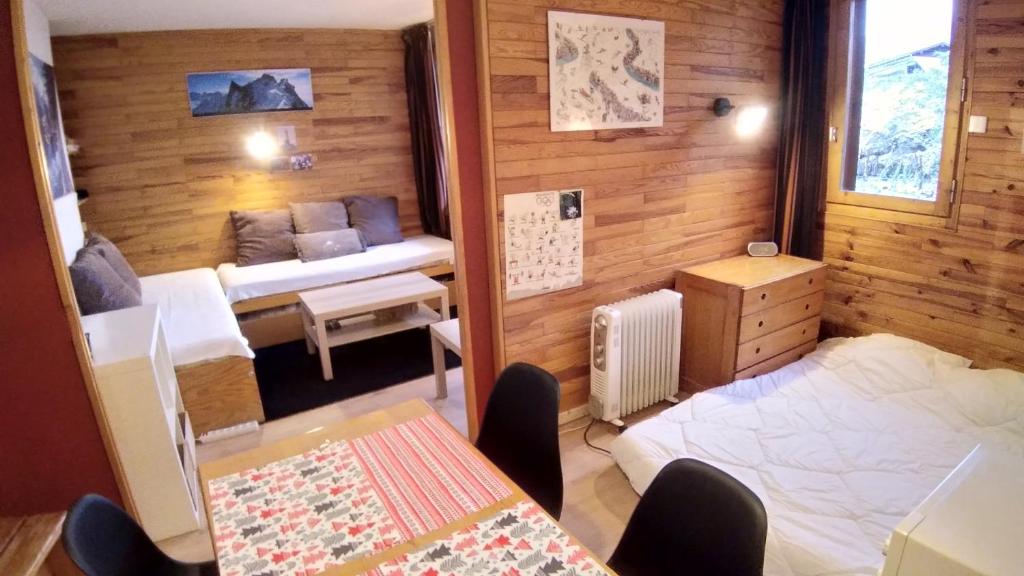 Plagne VillagesにあるPlagne Villagesのベッド、テーブル、椅子が備わる小さな客室です。