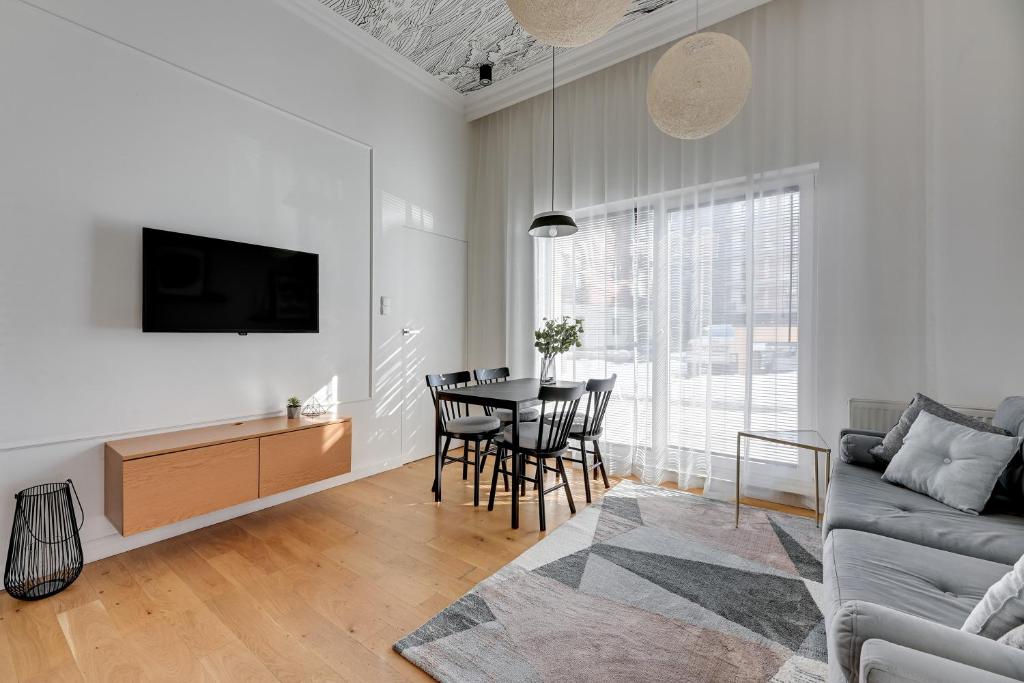 a white living room with a table and a couch at Downtown Apartments Chmielna Park - City Center & Parking in Gdańsk