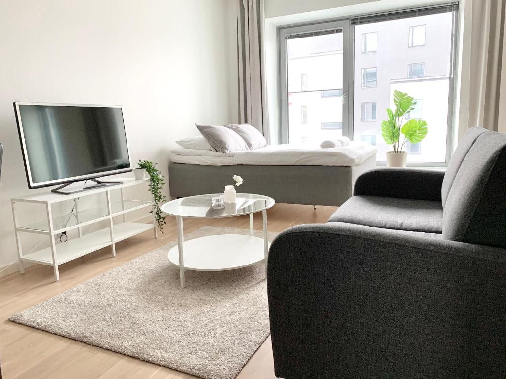 a living room with a couch and a tv at City Home Finland Big Luxury Suite - Spacious Suite with Own SAUNA, One Bedroom and Furnished Balcony next to Train Station in Tampere