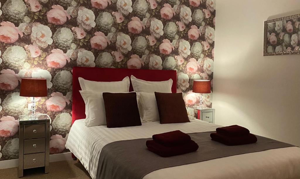 a bedroom with a bed with a floral wall at Le Patio in Évran