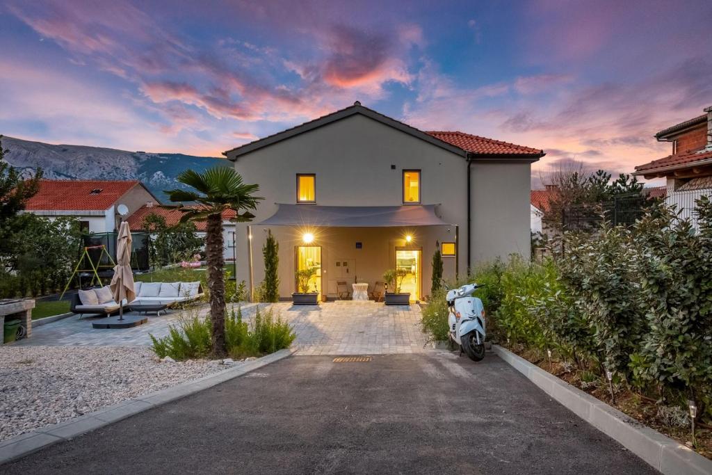 a house with a scooter parked in the driveway at Tarari Luxury Apartment in Baška